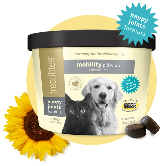 Light yellow canister of Treatibles Happy Joints Mobility Pill Wrap Chewables featuring a black cat and golden retriever along with two Chewables placed by the right front and a sunflower by the left front