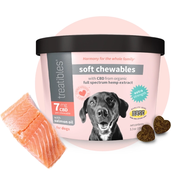 Image of the front of the pink canister of Treatibles Extra Strength CBD Soft Chewables for Dogs with two heart-shaped Chewables on the right and a salmon filet on the left